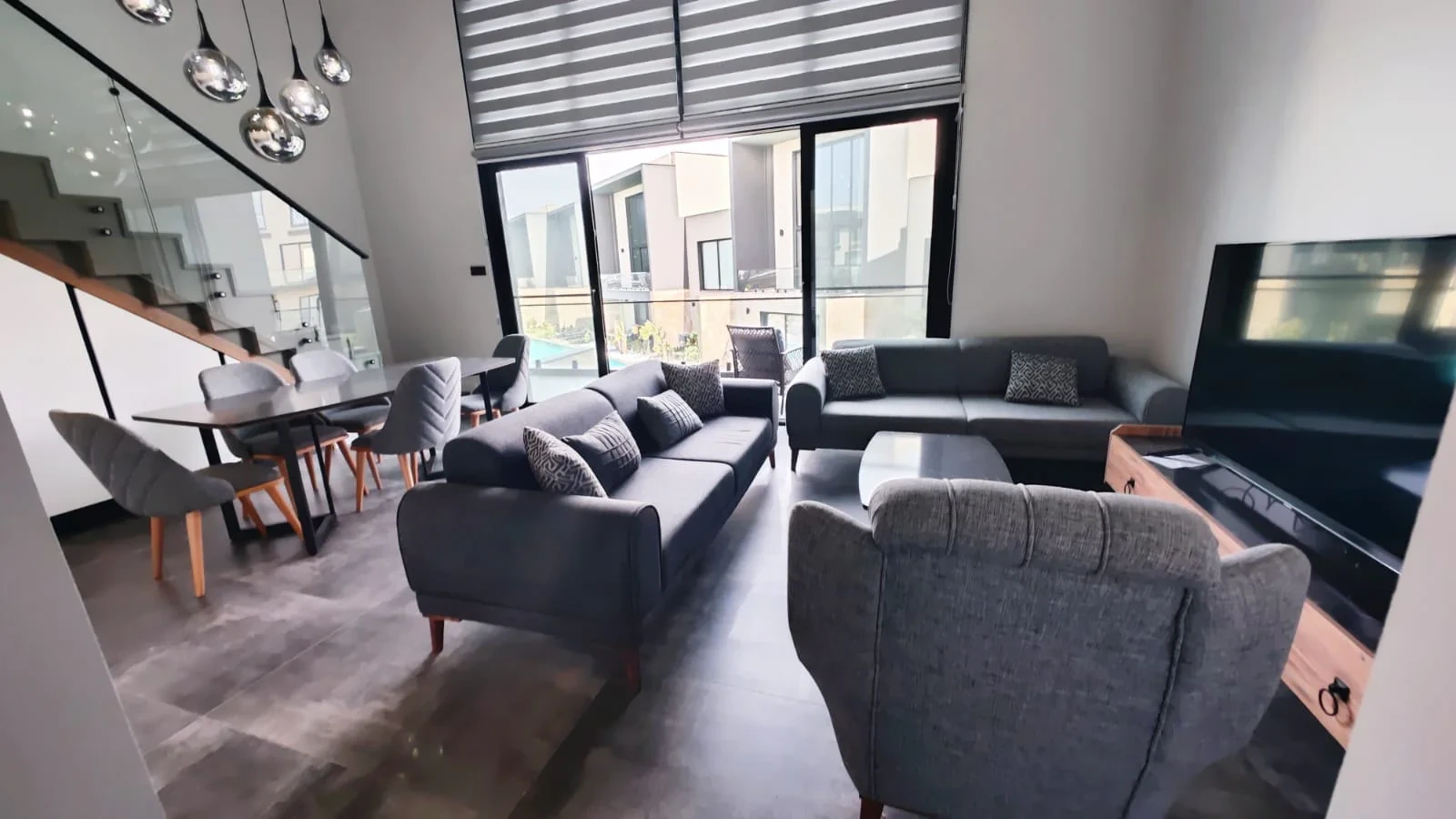 Furnished living and dining area with terrace access at Coastal Loft Penthouse